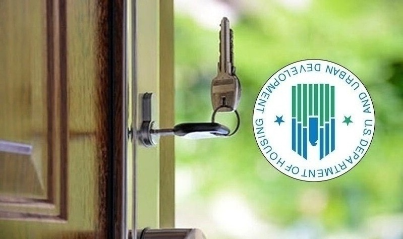 close up of home front door with keys in door lock and HUD logo overlaid on photo