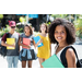 A girl smiling holding a notebook. Her three friends are standing behind her and waiting. 